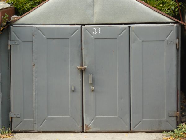 Heavy grey metal doors with lock in center and rusting edges.